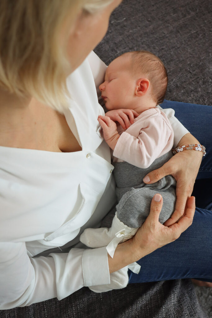 Baby Fotoshooting - Foto eines Babys wie es auf dem Schoss der Mutter schläft Foto eines Babys wie es auf dem Schoss der Mutter schläft