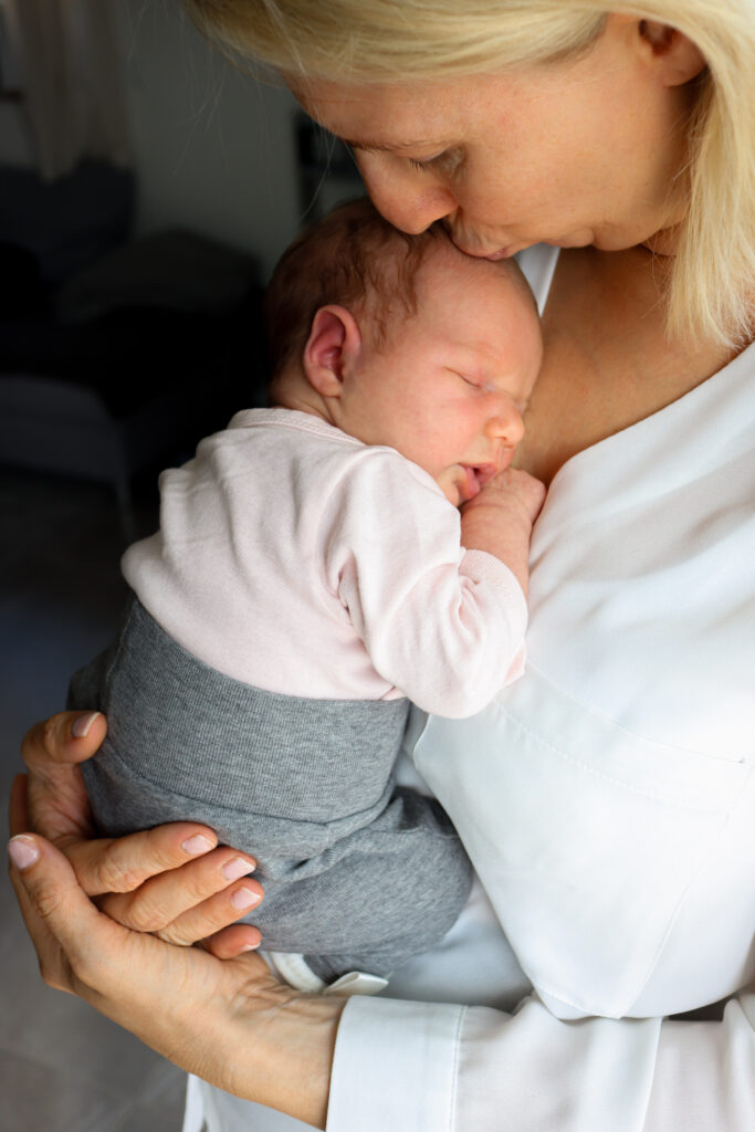 Baby Fotoshooting - Foto einer Mutter, wie sie ihr Baby auf den Kopf küsst Foto einer Mutter, wie sie ihr Baby auf den Kopf küsst