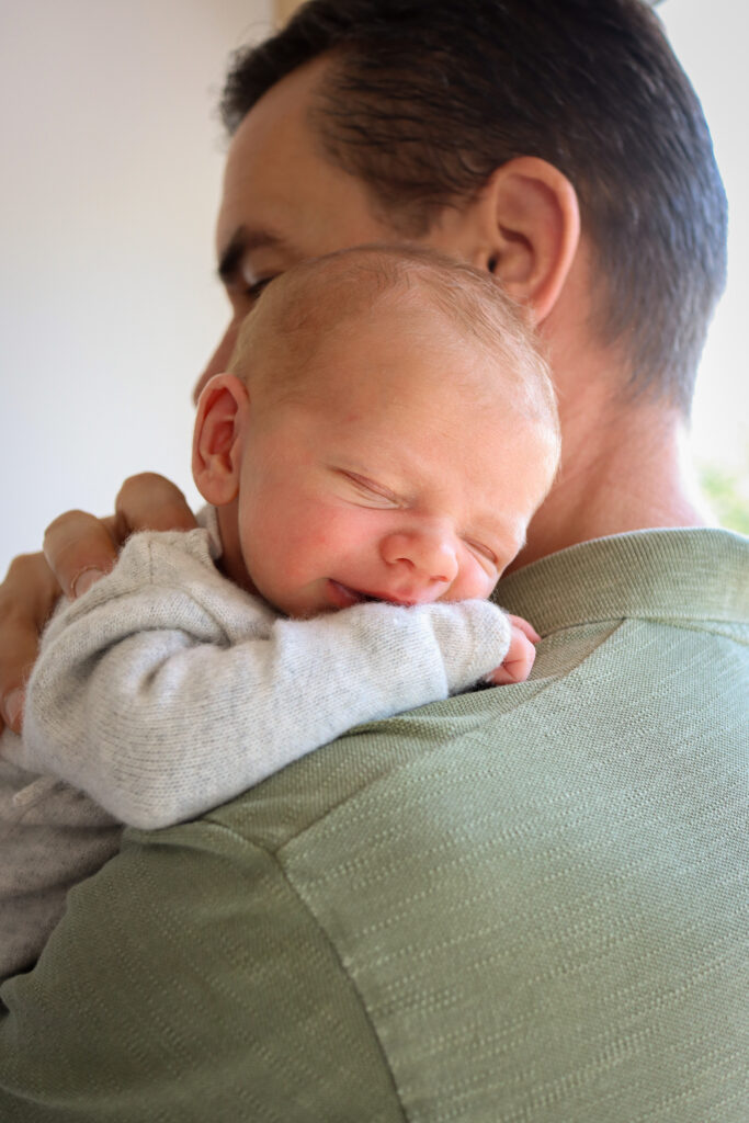 Baby Fotoshooting – Foto eines Babys auf dem Arm seines Vaters Foto eines Babys auf dem Arm seines Vaters