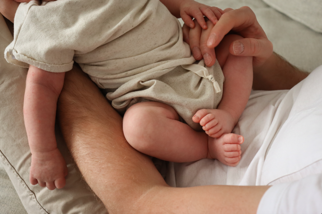 Baby Fotoshooting - Foto eines Babys auf dem Schoss des Vaters Foto eines Babys auf dem Schoss des Vaters