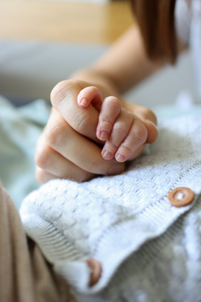 Baby Fotoshooting - Foto von den Fingern eines Babys wie es die Hand der Mutter festhält Foto von den Fingern eines Babys wie es die Hand der Mutter festhält